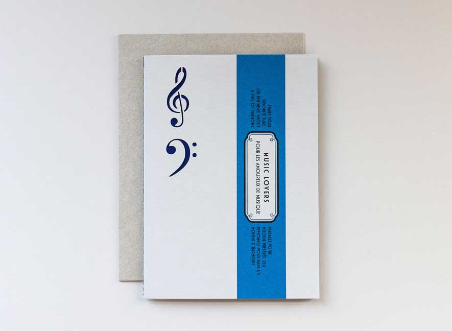 Luxury greeting card in the shape and feel of a playful vinyl record album with electric blue colors and intricate treble and base clef cutouts.