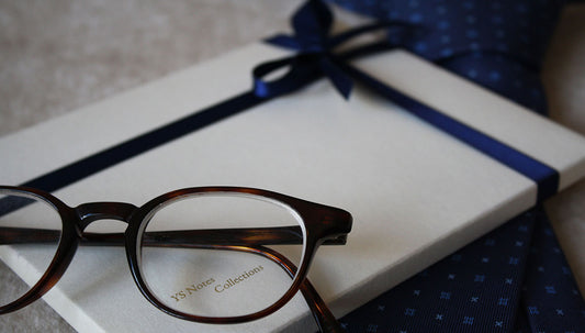 Gift-wrapped greeting card next to reading glasses and a bowtie