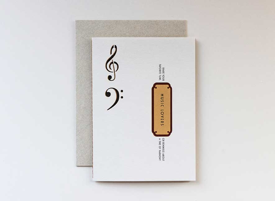  Luxury greeting card. Two-ply card using cream cotton cardstock with intricate treble and base clef cutouts on the exterior. Interior is smooth mustard-yellow paper with maroon accents. English-only version.